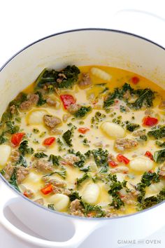 a pot filled with soup and vegetables on top of a white stovetop burner