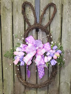 a wreath with purple and white flowers in the shape of a bunny's head