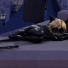 a catwoman doll laying on top of a table next to a pair of scissors