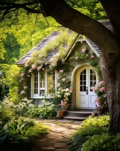 a house with flowers growing on the roof and door, surrounded by greenery in front of it