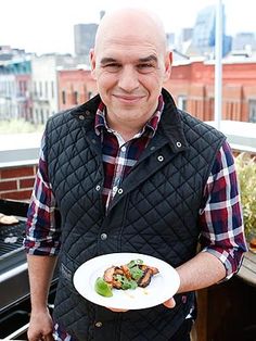 a man holding a plate with food on it