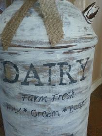 a large white painted jar with the words dairy written on it and a brown bow