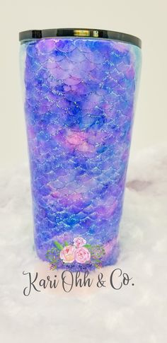 a purple and blue vase sitting on top of a white surface with water droplets all over it