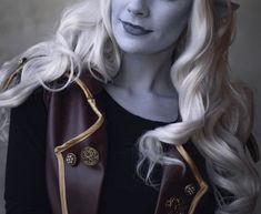 a woman with white hair and makeup is dressed in costume