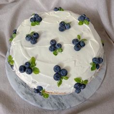 a cake with white frosting and blueberries on it