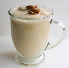 a glass mug filled with pudding and topped with almonds