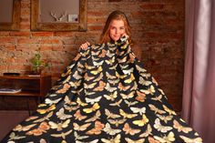 a woman standing in front of a black dress with butterflies on it