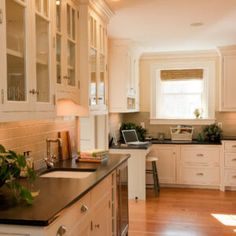 a kitchen with white cabinets and black counter tops is seen in this image from the inside