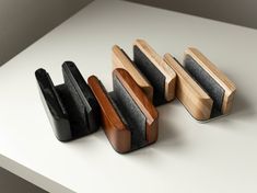 four wooden and metal objects sitting on top of a white table next to each other