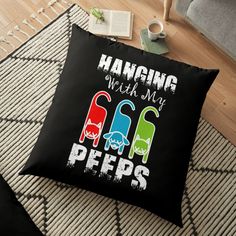 a black floor pillow with the words hanging with my pees on it and three different colors