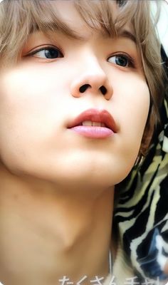 a close up of a person wearing a zebra print shirt with his head tilted to the side