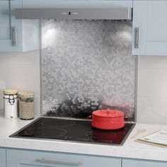 a stove top oven sitting inside of a kitchen next to blue cabinets and counter tops