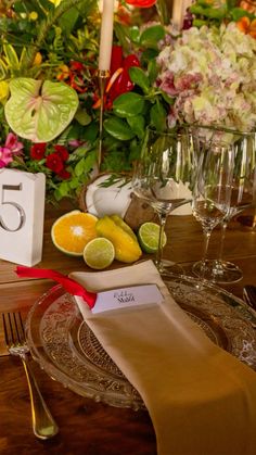 the table is set with flowers and fruit for an elegant dinner party or celebration,