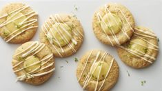 four cookies with white icing and green sprinkles sitting on a plate