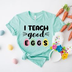 I Teach Good Eggs Shirt, Teacher Shirt, Easter Teacher Shirt, Easter Colourful Egg Shirt, Teacher Gift, Peeps Tee, Teacher Life Easter Shirt Black design for Athletic Heather, White, Baby Blue, Pink, Orange, Heather Peach, Yellow, Banana Cream, and Desert Pink. White design for all other colors Premium quality printed in the USA. Free Shipping on orders over $35 (US only) Printed in the USA High quality, durable shirts, sweatshirts, hoodies etc. A B O U T U S We offers custom t-shirts for any occasion! Whether it is a birthday, engagement, bachelor party, or a gender reveal celebration, we have you concerned. Check out our funny t-shirts that can make great gifts! For custom work or special requests, please contact us! D E T A I L S * 100 % Handmade * Combed with cotton and poly graphic te Cute Spring Shirt With Funny Text, Cute Shirt With Funny Text For Spring, Spring Cotton Shirt With Funny Text, Fun Cotton Tops For Easter, Funny Printed Cotton Shirt, Green Short Sleeve Shirt With Funny Text, Funny Green Cotton Shirt, Cute Green Shirt With Funny Print, Green Cotton Shirt With Funny Text