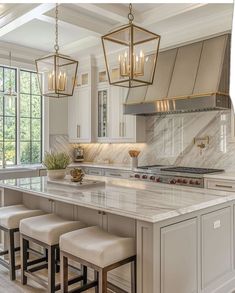 a kitchen with white cabinets and marble counter tops, an island with four stools