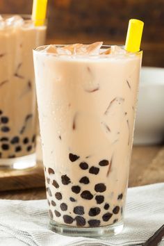 two glasses filled with milkshakes sitting on top of a table