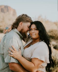 a man and woman embracing each other in the desert