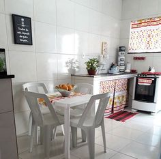 a white table and chairs in a small room with tile flooring on the walls