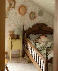 a child's bed in a bedroom with floral wallpaper and wooden headboard