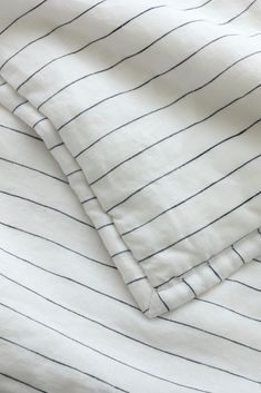 two white and black striped sheets laying on top of each other