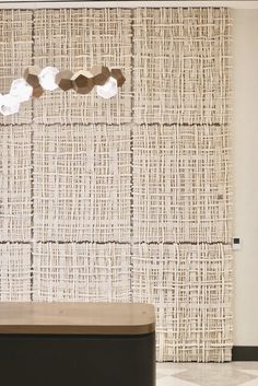 a bench sitting in front of a wall covered with burlocked fabric panels