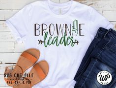 a t - shirt with the words brownie mom on it next to jeans and sandals