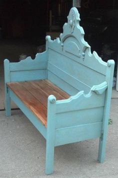 a blue wooden bench sitting on top of a cement floor next to a garage door