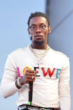 a man with glasses holding an umbrella and wearing a white t - shirt that says love