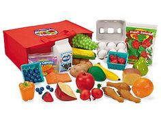 an assortment of fruits and vegetables are shown in front of a red box with the lid open