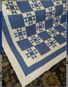 a blue and white quilt is on display in front of a computer screen with the words,