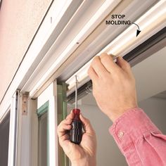 a man is holding a screwdriver to the side of a window sealer