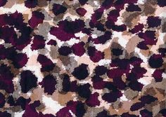 an animal print fabric is shown in shades of purple, brown and white with black spots