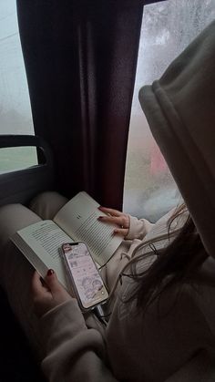 a woman is reading a book on the train