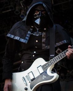 a man wearing a gas mask playing an electric guitar