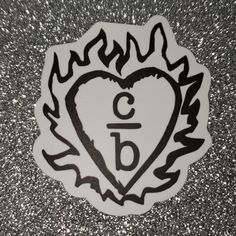 a sticker with the letter b is in the shape of a heart and flames