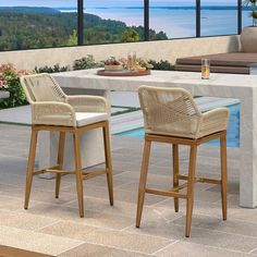 two wicker bar stools sitting in front of a table