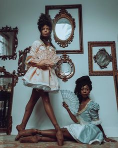 two women sitting on the floor in front of mirrors and holding parasols,