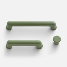 three green handles and two knobs on a white surface