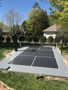 a tennis court surrounded by grass and trees