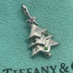 Rare Tiffany & Co. 18k White Gold Christmas Tree Charm With Pink Sapphire, Diamonds, And Tsavorites - Impeccable Condition This Exquisite And Authentic Tiffany & Co. 18k White Gold Christmas Tree Charm Is A True Collector's Piece, Featuring Stunning Pink Sapphires, Brilliant White Diamonds, And Vibrant Green Tsavorites. In Like-New Condition, This Charm Has No Visible Wear, And All The Gemstones Are Intact, Sparkling Brilliantly. It Has Been Expertly Cleaned And Polished, Ensuring It Looks As Ra Tiffany Ornaments, Tiffany Christmas, Pendant Jewelry Tiffany & Co., Letter Pendant Necklace Tiffany & Co., 1960s Tiffany & Co. Jewelry, Christmas Tree Charm, White Gold Sapphire, Gold Christmas Tree, Gold Christmas