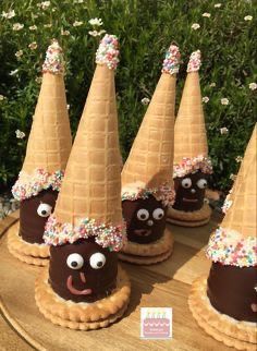 chocolate covered ice cream cones with sprinkles and eyes on them, sitting on a wooden table