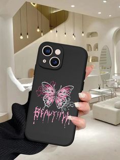 a person holding up a phone case with a butterfly on it