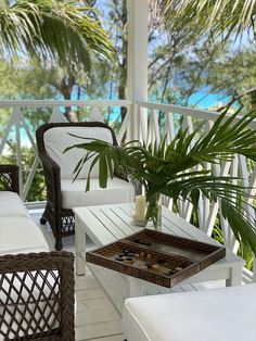 a porch with wicker furniture and palm trees