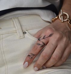 a woman's hand with an arrow tattoo on it