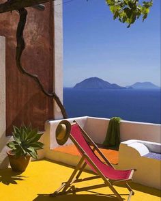 a red and white chair sitting on top of a yellow floor next to a tree