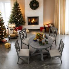 a dining room table with chairs and a christmas tree in front of the fire place