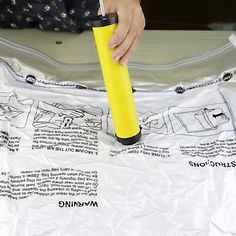 a person holding a yellow umbrella on top of a piece of plastic