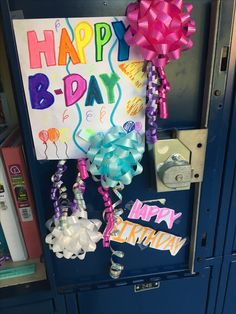 a happy birthday sign hanging from the side of a blue locker with balloons and streamers attached to it