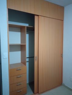 an empty closet with wooden doors and drawers